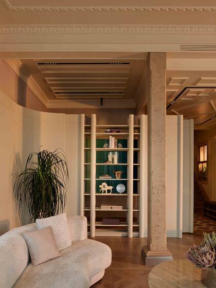 Materiales naturales como mármol travertino en las columnas y madera de roble aportan calidez y sofisticación.