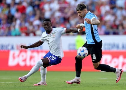 Mathias Olivera corta el avance de Folarin Balogun; el zaguero de Uruguay convirtió el gol del triunfo charrúa, el atacante estadounidense se retiró lesionado en el primer tiempo