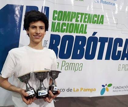 Matías con trofeos de la competencia nacional de robótica