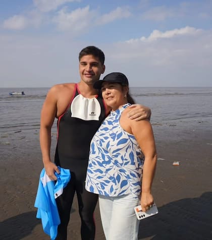 Matías Díaz Hernández junto a su mamá a poco de salir del agua en la costa argentina, en Punta Lara.