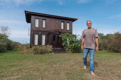 Matías, posando para ¡HOLA! Argentina con una de las remeras que diseña y su casa detrás