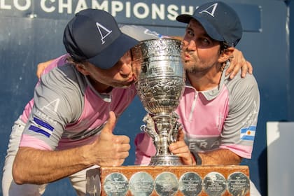 Matt Coppola y Diego Cavanagh besan la copa, que en la base lleva los nombres de todos los polistas que pudieron conquistarla.