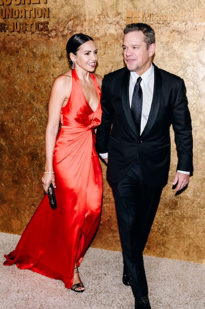 Matt Damon -muy amigo de Clooney- y su mujer argentina Luciana Barroso, que impactó con un diseño rojo de seda con escote halter. 