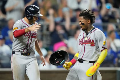 Matt Olson, izquierda, y Ronald Acuña Jr., de los Bravos de Atlanta, celebran después de anotar con un doble productor de tres carreras de Austin Riley durante la octava entrada del juego contra los Reales de Kansas City, el lunes 28 de julio de 2025, en Kansas City, Missouri. (AP Foto/Charlie Riedel)