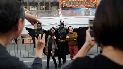Matthias Balke, con su atundo de Batman, posa con los turistas en Hollywood Boulevard cerca del Teatro Dolby en Los Ángeles.