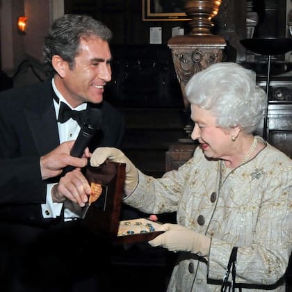 Maurice Ostro con la reina Isabel y el collar que le hizo especialmente su compañía