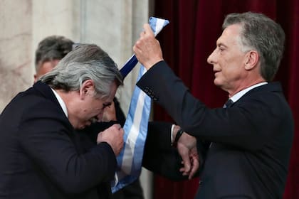 Mauricio Macri le coloca la banda al presidente de la Nación, Alberto Fernández