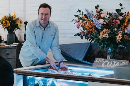Max Raide sacando una centolla de la pileta de Casa Las Cujas, su restaurante