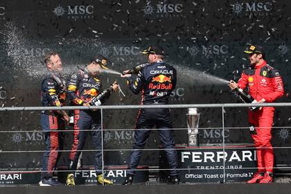 Max Verstappen (centro) celebrando su victoria en el podio del Gran Premio de Bélgica, con el segundo Checo Pérez (segundo a la izquierda) y Charles Leclerc (derecha), en Spa