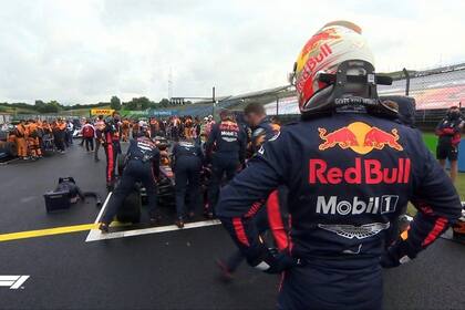 Max Verstappen, de casco, observa el inicio de las reparaciones del RB16, tras el accidente en la Curva 12: en la grilla, los mecánicos lograron en 20 minutos devolver a la carrera al neerlandés, que logró el segundo puesto en el Gran Premio de Hungría