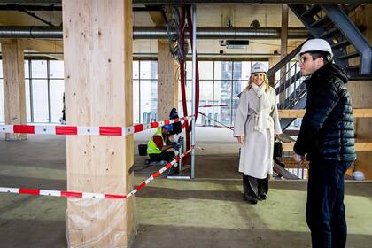 Máxima se lució con un abrigo gris, botas negras y se calzó el casco para protegerse la cabeza