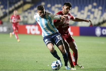 Maximiliano Romero cubre el balón delante de Nicolás Zalazar; en Concepción, Racing hizo diferencia y luego reguló para cuidarla.