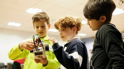 Máximo, Tiago y Marcio debaten sobre el diseño de un robot en el curso Robotito del ITBA