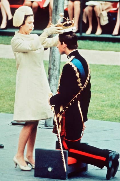 MAYORÍA DE EDAD. El 1 de julio de 1969, arrodillado ante su madre, Carlos, de 20 años, fue investido con el título de príncipe de Gales, en el castillo de Caernarfon. Su formal respuesta fue: “Yo, Carlos, príncipe de Gales, me convierto en su vasallo de por vida y de adoración terrenal y de fe y verdad para vivir y morir ante toda clase de personas”.