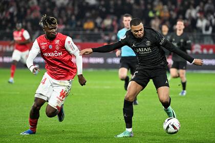 Mbappé lleva la pelota ante la presencia del defensor de Reims Reims Emmanuel Agbadou