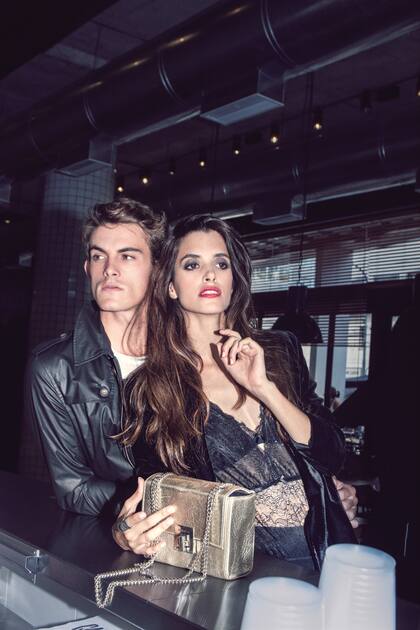 Mechi: corpiño y body de encaje (Caro Cuore); saco de paño (Vitamina), anillo de plata ($ 340, Cuatro Musas) y cartera de cuero ($ 2300, Vitamina); Mateo: remera escote redondo ($ 890, Bolivia) y trench engomado ($ 4150, Perramus)