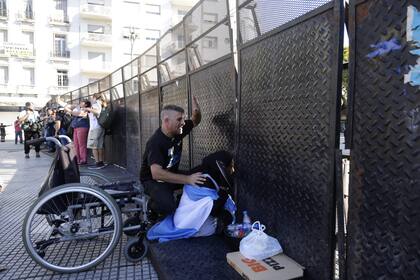 Meda Florián, junto a un manifestante, a la sombra de las vallas del Congreso