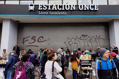 Varias personas esperan que la estación de trenes de Once levante sus persianas y reanude el servicio
