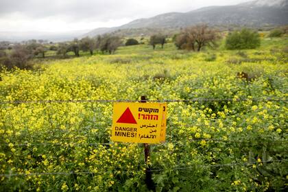 Una señal de advertencia de minas terrestres en un campo en los Altos de Golán. Gran cantidad de turistas pasan por la zona camino a lugares populares en las vacaciones