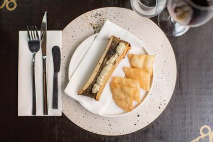 Médula de llama rostizada con puré de berenjenas asadas y chips crocantes, un plato que se puede comer en Finca. 