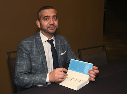 Mehdi Hasan firmando uno de sus libros