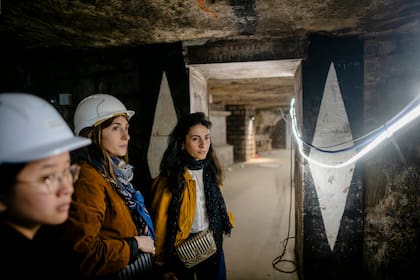 Mélissa Cayralat (a la derecha, sin casco), la arquitecta líder del proyecto de renovación de las Catacumbas de París, contó que tuvieron dificultad para encontrar gente que quisiera trabajar 60 pies bajo tierra y rodeados de huesos humanos (Dmitry Kostyukov/The New York Times)