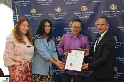 Melody Amal Khalil Kabalan; Nadima Khalil Kabalan e Ismael Khalil Kabalan; el embajador de Malasia, Azman Rahim, mientras recibían el certificado