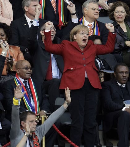Merkel celebra junto al presidente sudafricano, Jacob Zuma, después de que el alemán Thomas Mueller anotara un gol durante el partido de cuartos de final de la Copa del Mundo entre la Argentina y Alemania en el estadio Green Point en Ciudad del Cabo, Sudáfrica, el 3 de julio de 2010