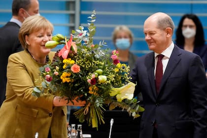 Merkel recibe un bouquet de flores de parte de Scholz