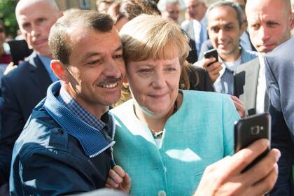 Merkel se saca una selfie con un refugiado sirio. Alemania abrió las puertas a los migrantes que huían de la guerra