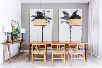 Mesa antigua de cedro. Sillas ‘Wishbone’ (Marabierto). Dressoire en madera de petiribí (Sol Palou Deco). Lámparas antiguas compradas en el Mercadillo de Sotogrande, España.