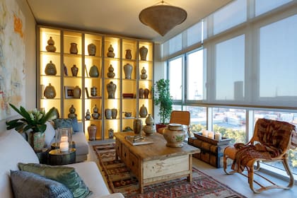 Mesa antigua, sillas de ratán, alfombra, almohadones y una colección de vasijas vietnamitas que, en Desde Asia, también convierten en lámparas. Sofá (Hábito).