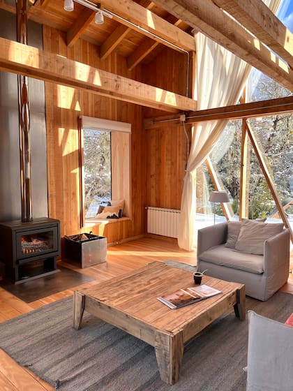 Mesa baja hecha a mano con raulí y postigos antiguos. Alfombra a medida confeccionada por artesanas del Norte (Fundación Urdir).