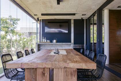 Mesa con tablones de pino tea recuperados. Camino (Guazu Nambi). Sillas de PVC negro (Prestigio). Ventanas ‘A40′ de aluminio microtexturado color grafito.