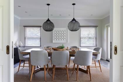 Mesa con tapa de cuero (Harturo). Sillas con estructura de petiribí tapizadas en pana gris y fundas de lino lavables del mismo color.