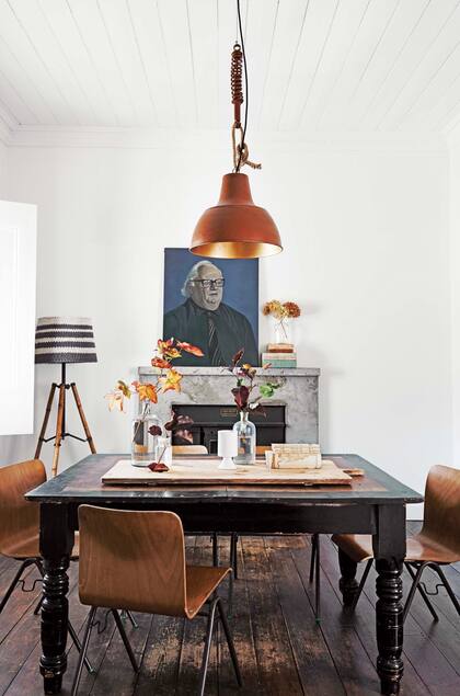 Mesa de campo antigua, comprada hace aos en un mercado, sillas danesas de los 50 y lmpara galponera de cobre. Sobre la chimenea, cuadro sin firma, otro hallazgo de feria.