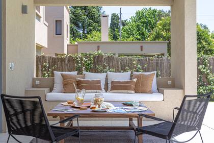 Mesa de centro ‘Patagonia’ de guayubirá (Galpón Osuna) con sillas de soga ‘Tihla’ (Increa), alfombra y almohadones (Somos Frontera).