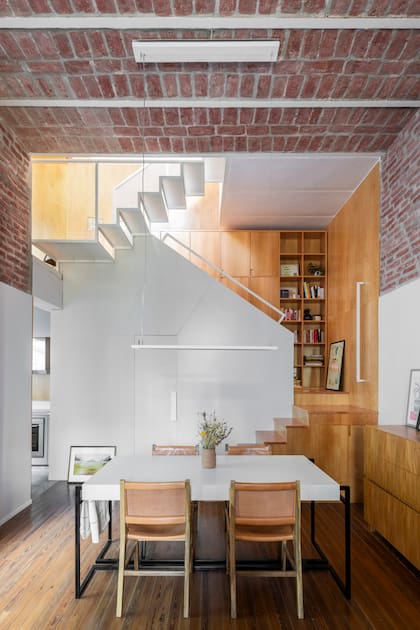 Mesa de comedor con estructura de hierro y tapa de Silestone ‘Statuario Suede’ y cómoda enchapada en paraíso (Arq. Laura Libenson). Sillas ‘Salvaje Invierno’ (Wood Market).