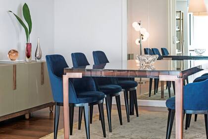 Mesa de comedor 'Dylan' y vajillero (ambos de Eugenio Aguirre). Sillas de pana azul (Missura). Lámpara 'Tolomeo Sospensione Pergamena' (Iluminación Agüero) y alfombra 'Silky Border' (Mihran).