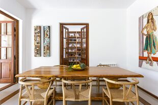 Mesa de comedor hecha a medida (Marcelo Manrique). Juego de sillas ‘Wishbone’ (Pasto Home). Óleo de figura femenina (Lola Erhart).