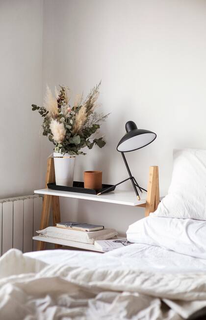 Mesa de luz con estantes (Cool Wood), lámpara (Ikon Lamps), bandeja (VK Home) y flores (Chal Chal).