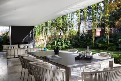 Mesa de Neolith 'Pietra di Luna Silk' con base de acero inoxidable, sillas importadas (TW) y sofás vintage (Sol Larrosa).