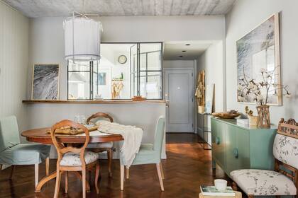 Mesa de petiribí macizo y dos sillas de la abuela de Josefina, y otras con funda verde de Apatheia, al igual que la consola y la lámpara colgante.