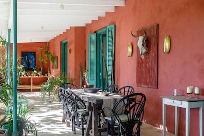 Mesa de quebracho con camino de Linos Vintage y sillas tipo Mar del Plata. Flanqueando la calavera de vaca, candelabros de bronce (Sixta).