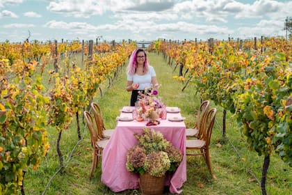 Mesa diseñada especialmente para Pascuas con frutas, verduras, flores y huevos sobre mantel cuadrillé entre los viñedos de Bodega Gamboa en Campana.