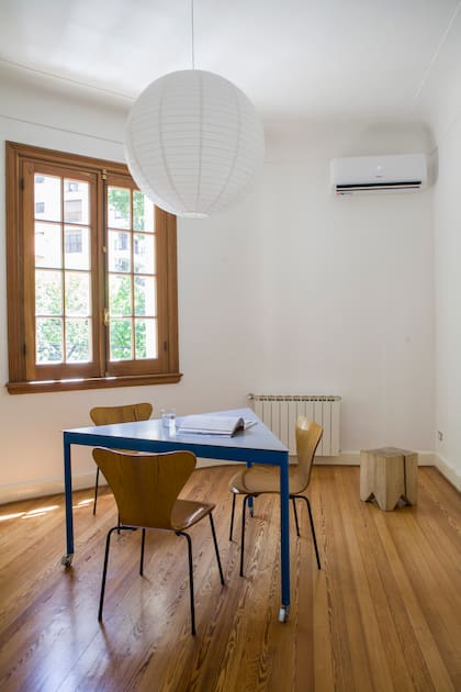 Mesa diseñada por el arquitecto Facundo Fernández (Flora Oficina). Sillas vintage ‘Serie 7’, de Arne Jacobsen; su terminación reitera casi con exactitud el tono del piso y de las aberturas. Taco ‘Álamo’ (La Base Studio).