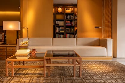 Mesa en madera y cristal y sofá de tres metros tapizado en pana diseñada por Roig. Alfombra tibetana (Mihran).