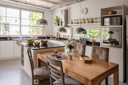 Mesa hecha a medida y lámpara (Phillips). Cuencos y velas de madera tallada (Artisan).