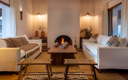 Mesa ratona de petiribí (Etchegaray Ramos Mejía Arquitectas). Poncho salteño del dueño de la finca, sofás con funda (Proyecto MAC, de Salta), almohadones (Malena y Ana), banquetas (MDS Diseño), alfombra de yute (Puskano Alfombras), alfombra tejida (Malena y Ana)