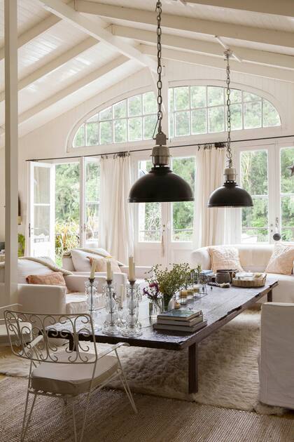 Mesa ratona hecha con una puerta antiquísima. Candelabros, portaespiral de cerámica y escultura de hierro (todo de 7-27 Home Collection).